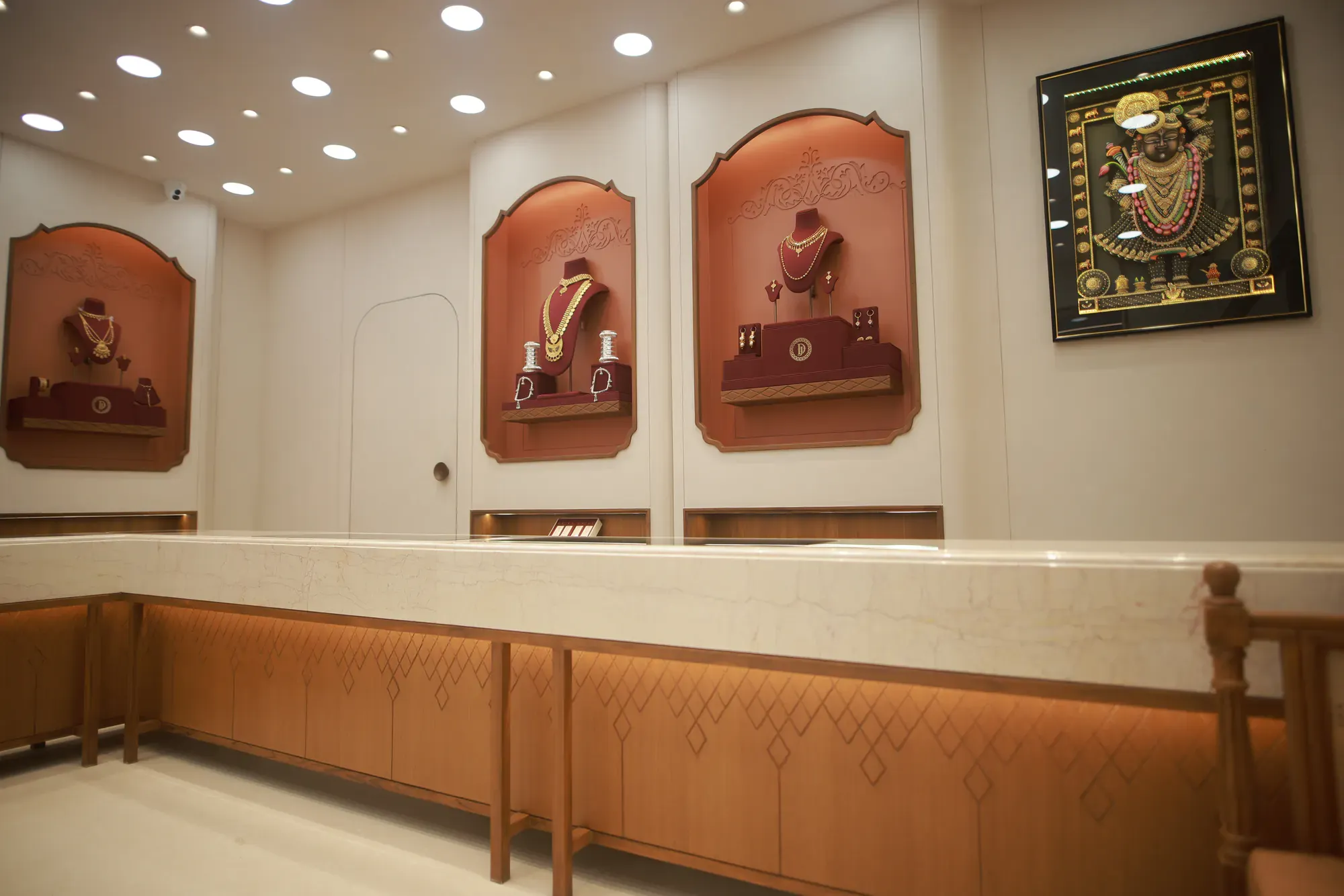 Inside the Dhanlaxmi Jewellers showroom, with arched niches and a marble counter